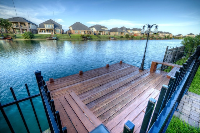 view of dock featuring a residential view and a water view