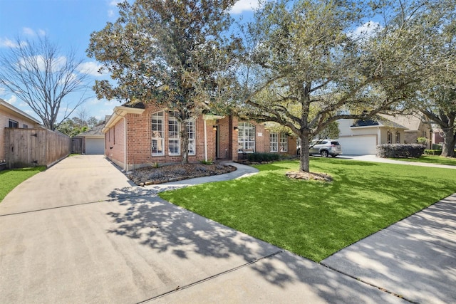 view of property hidden behind natural elements featuring a front yard, brick siding, and fence