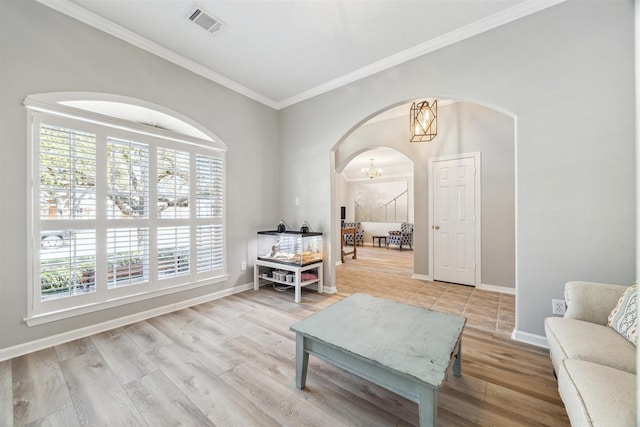 sitting room with light wood finished floors, visible vents, arched walkways, baseboards, and an inviting chandelier