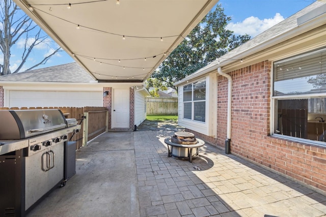 view of patio with a fire pit, an outdoor kitchen, and fence