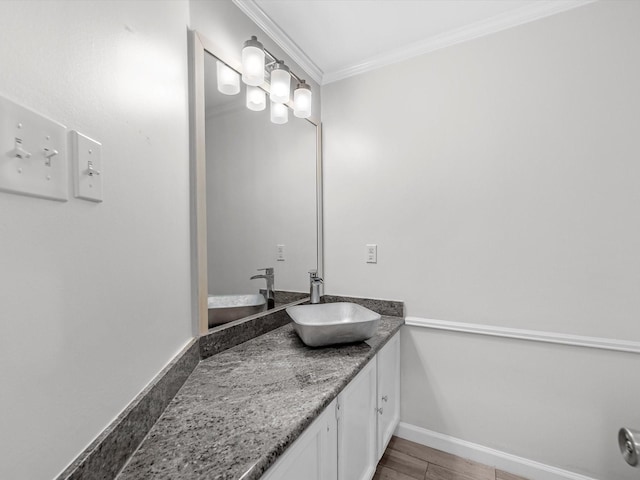 bathroom with wood finished floors, vanity, baseboards, mail area, and crown molding