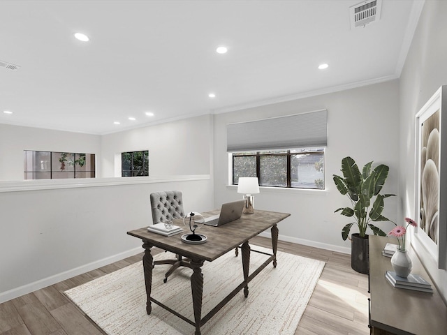 office area featuring crown molding, light wood finished floors, visible vents, and baseboards