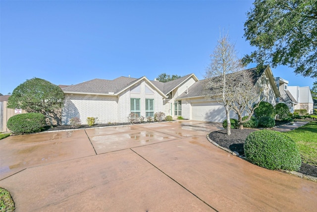 view of front facade featuring a garage, driveway, and brick siding