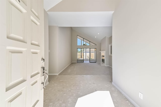 foyer with high vaulted ceiling and baseboards