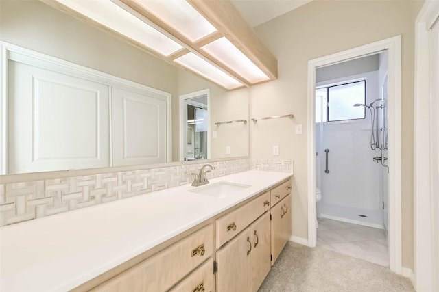 bathroom featuring tasteful backsplash, a stall shower, vanity, and baseboards