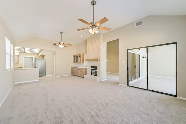 unfurnished living room featuring a fireplace, light colored carpet, visible vents, high vaulted ceiling, and baseboards