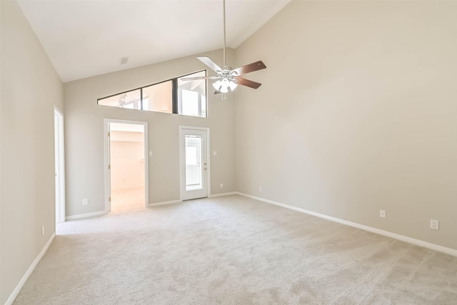 spare room with high vaulted ceiling, baseboards, and light colored carpet