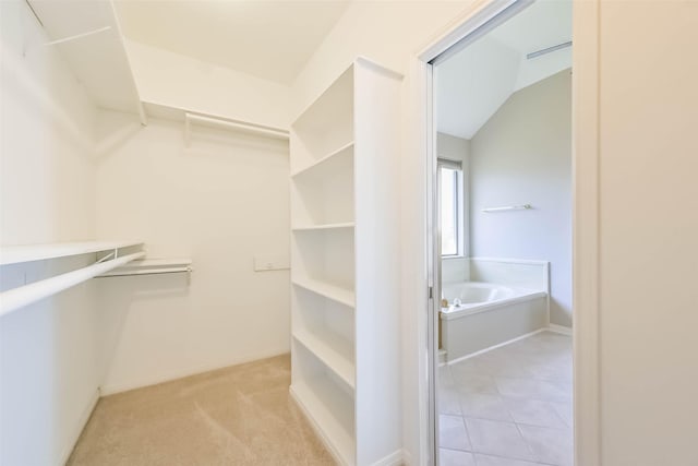 spacious closet featuring light tile patterned floors and light colored carpet