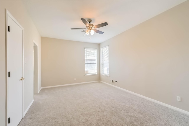 unfurnished room with light colored carpet, ceiling fan, and baseboards