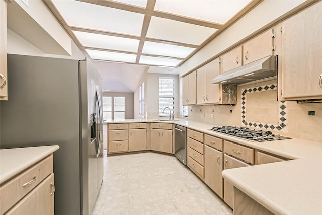 kitchen with stainless steel appliances, light countertops, under cabinet range hood, light brown cabinets, and a sink