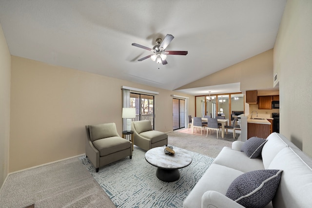 living area with baseboards, lofted ceiling, light colored carpet, and ceiling fan with notable chandelier