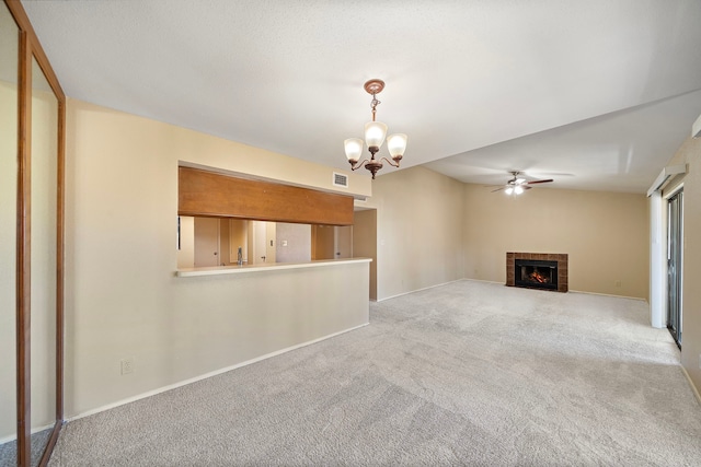 unfurnished living room with visible vents, baseboards, light colored carpet, ceiling fan with notable chandelier, and a tile fireplace