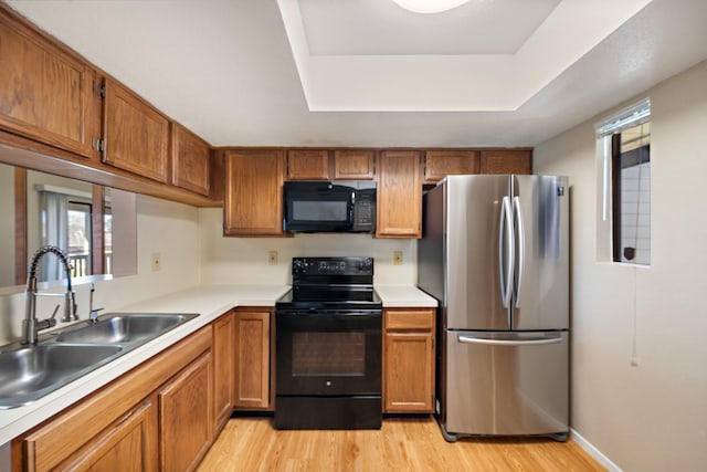 kitchen featuring a sink, black appliances, and brown cabinetry