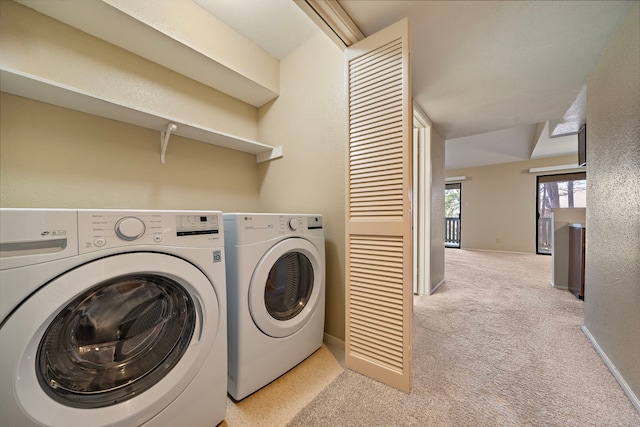 washroom featuring washing machine and clothes dryer, laundry area, light carpet, and baseboards