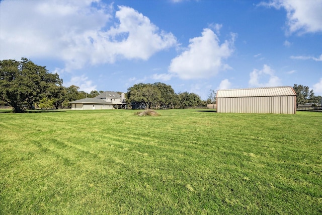 view of yard with an outbuilding, a pole building, and fence