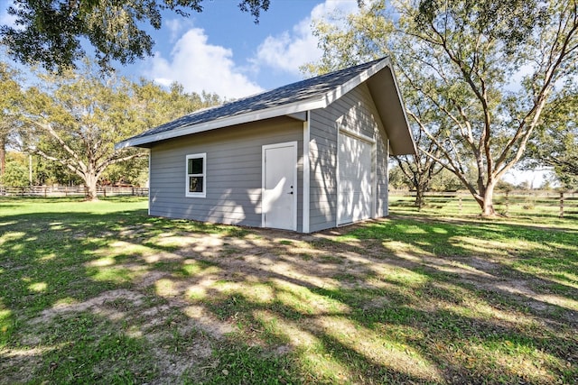 view of outbuilding featuring fence and an outbuilding