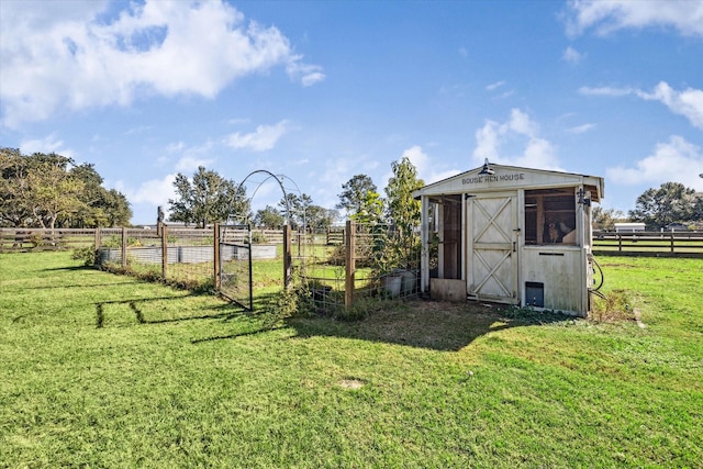 view of outdoor structure featuring a garden, fence, and a rural view