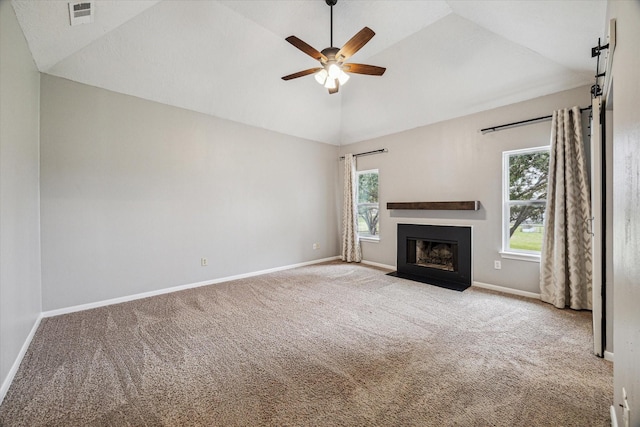 unfurnished living room featuring a fireplace with flush hearth, a healthy amount of sunlight, visible vents, and vaulted ceiling