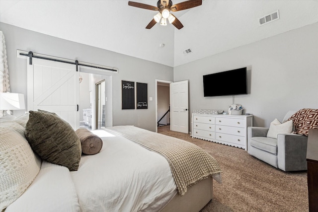 bedroom featuring ceiling fan, carpet floors, a barn door, and visible vents