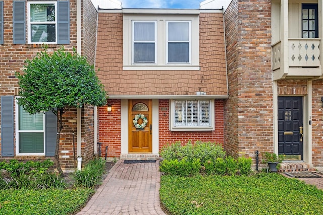 view of front of home with brick siding and mansard roof