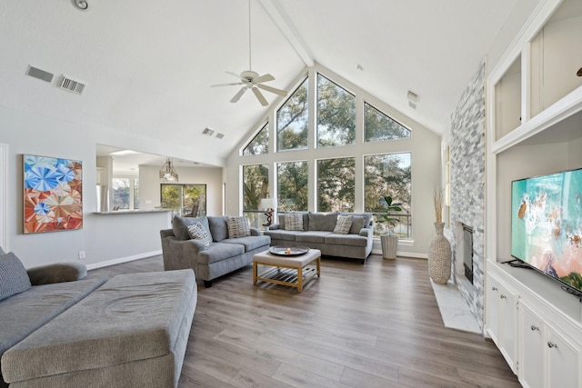 living room with high vaulted ceiling, a stone fireplace, wood finished floors, visible vents, and beam ceiling