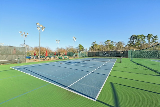 view of tennis court featuring fence