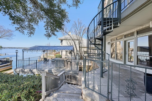 wooden deck featuring a water view, a patio area, and stairs