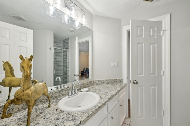 bathroom featuring a stall shower, visible vents, vanity, and a textured ceiling