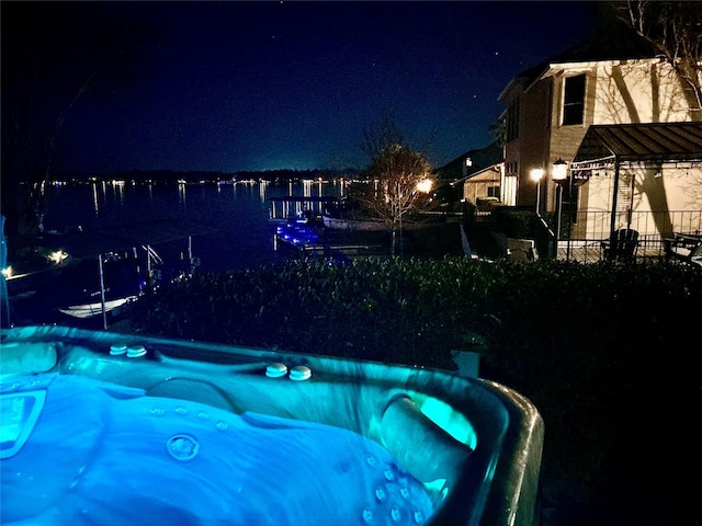 pool at twilight featuring a water view