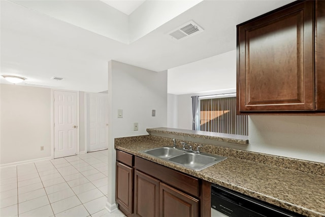 kitchen featuring dishwashing machine, dark countertops, a sink, and visible vents