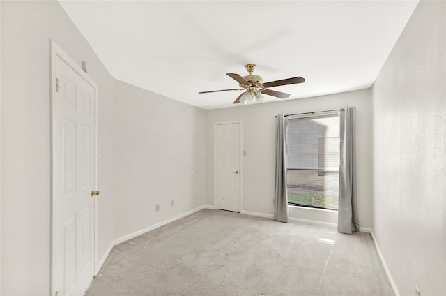 empty room with ceiling fan, baseboards, and light colored carpet