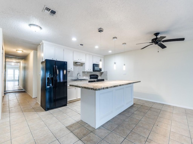 kitchen featuring a sink, visible vents, white cabinetry, black appliances, and decorative light fixtures