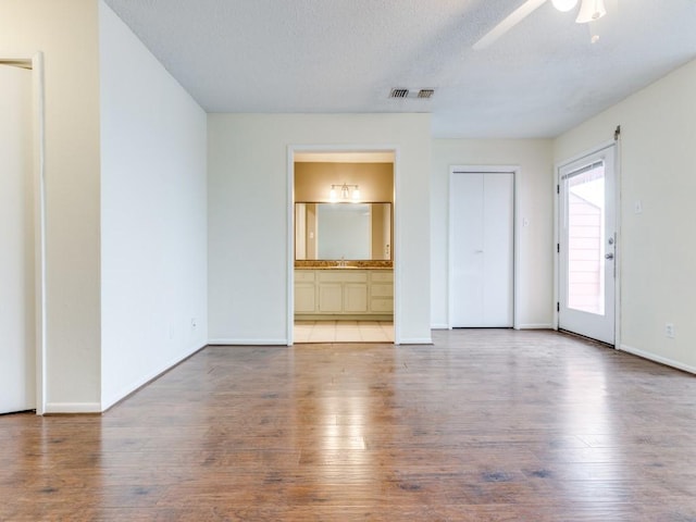 spare room with visible vents, ceiling fan, baseboards, and wood finished floors