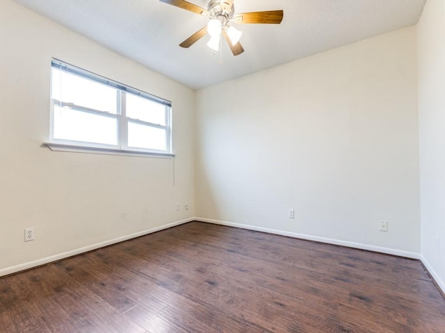 empty room with dark wood-style flooring, ceiling fan, and baseboards