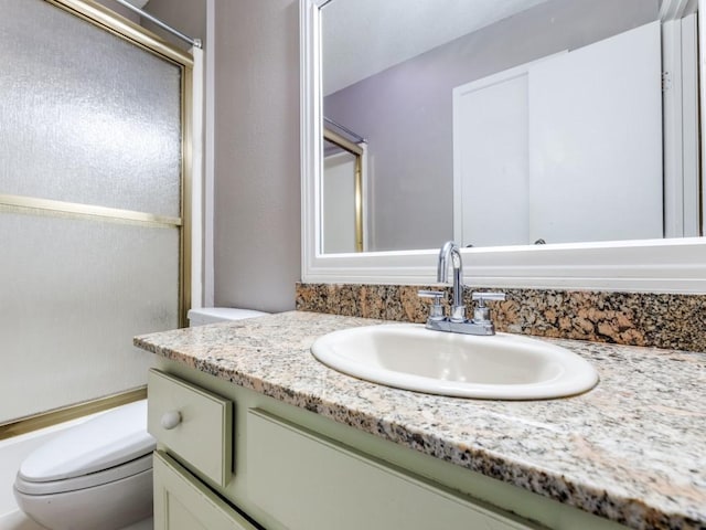 full bathroom with toilet, vanity, and enclosed tub / shower combo