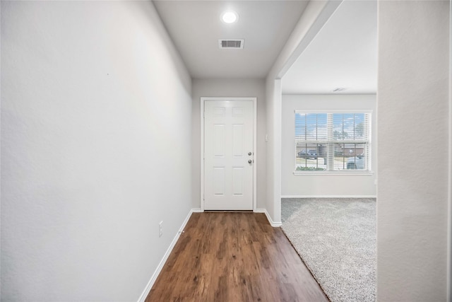 entryway with dark wood finished floors, visible vents, and baseboards