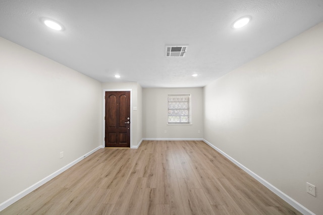 spare room with light wood-style flooring, recessed lighting, visible vents, and baseboards