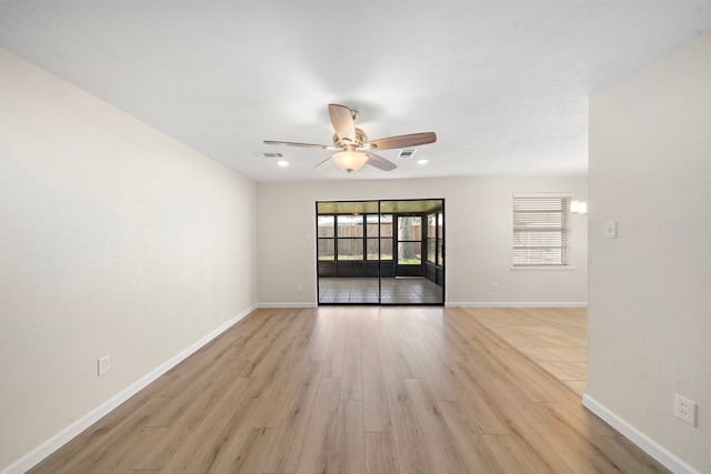 unfurnished room with light wood-style floors, visible vents, ceiling fan, and baseboards