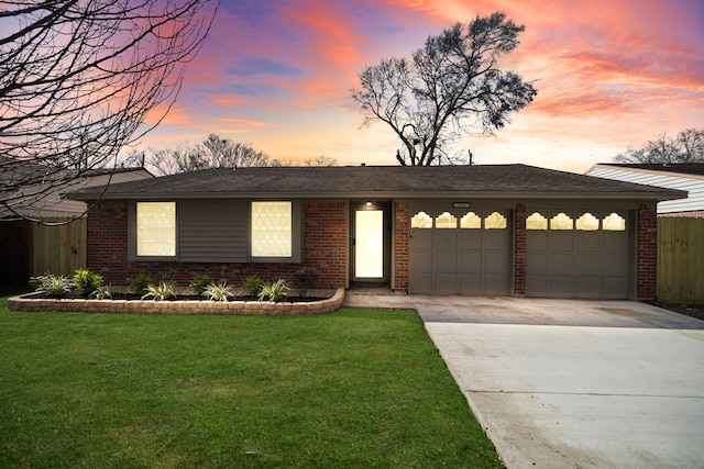 single story home featuring concrete driveway, a front lawn, an attached garage, and brick siding