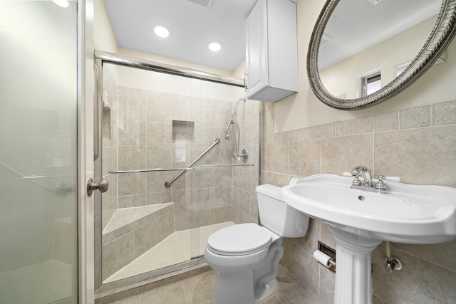 bathroom with toilet, tile patterned floors, a shower stall, tile walls, and recessed lighting