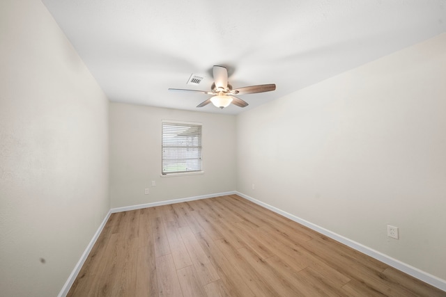 empty room with a ceiling fan, light wood-type flooring, visible vents, and baseboards