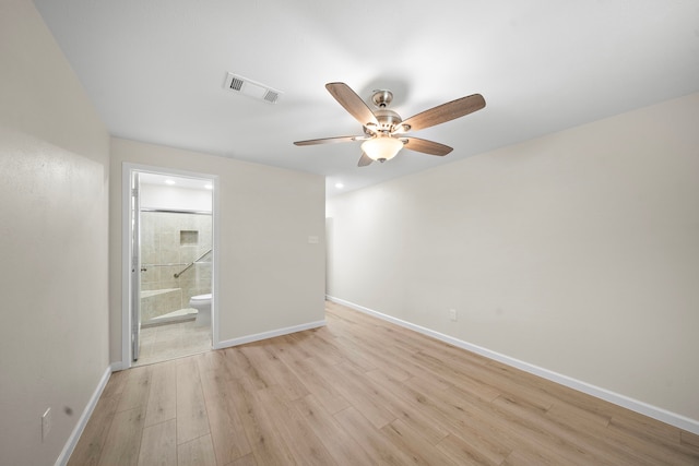 unfurnished bedroom featuring ceiling fan, visible vents, baseboards, light wood-style floors, and ensuite bath