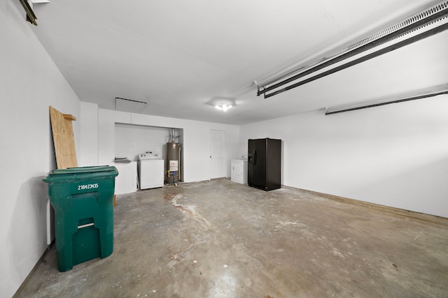 garage featuring black fridge, gas water heater, and washing machine and dryer