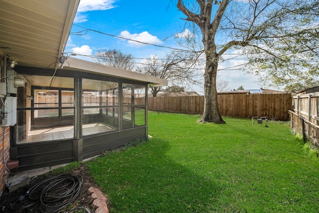 view of yard featuring a sunroom and a fenced backyard