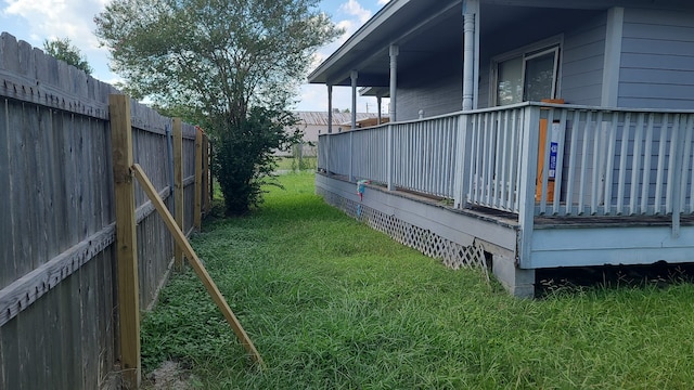 view of side of property featuring a fenced backyard, a lawn, and a deck