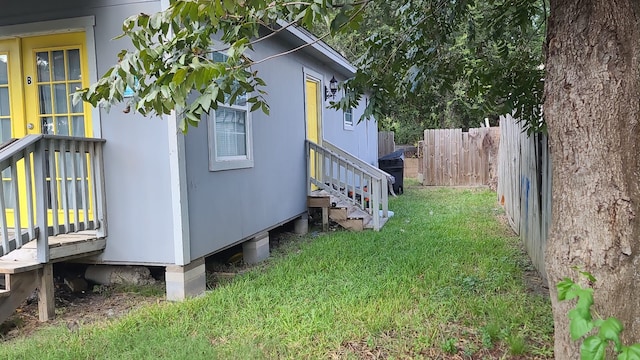 view of home's exterior featuring a lawn and fence