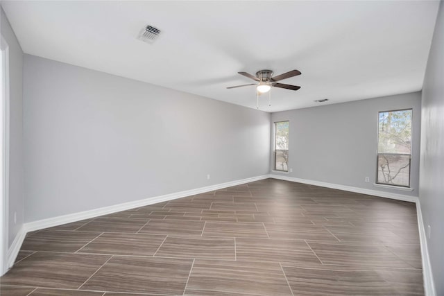 empty room with a ceiling fan, visible vents, and baseboards