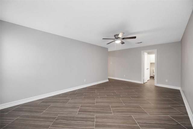 empty room with ceiling fan, wood tiled floor, visible vents, and baseboards