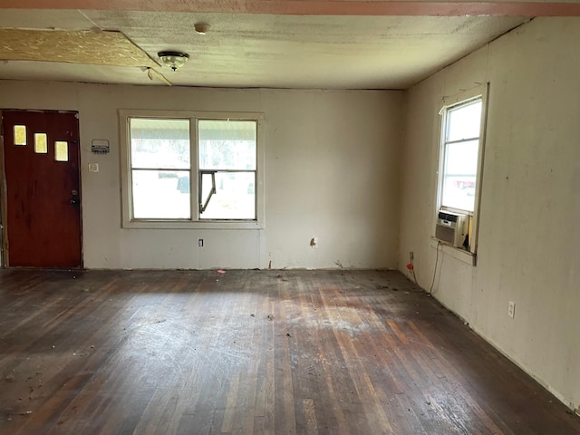 interior space featuring dark wood-style floors, cooling unit, and a healthy amount of sunlight