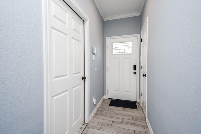 entryway featuring ornamental molding, wood finish floors, and baseboards